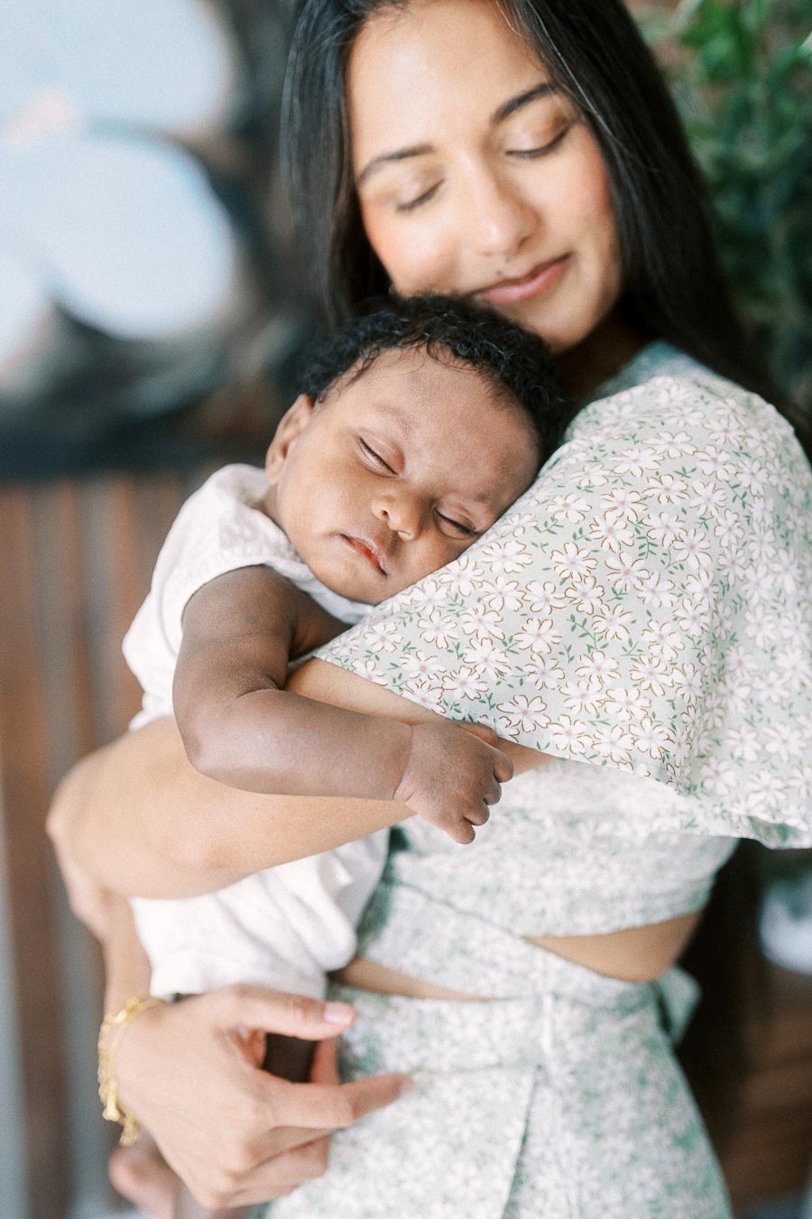 Karina cuddles sleeping Isabella against her shoulder at home in Toronto.