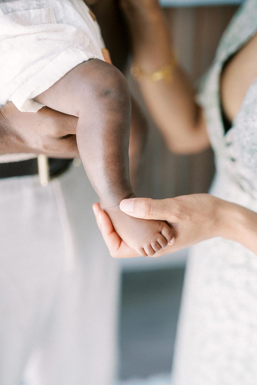 Mother gently holds newborn daughter Isabella’s tiny foot at home