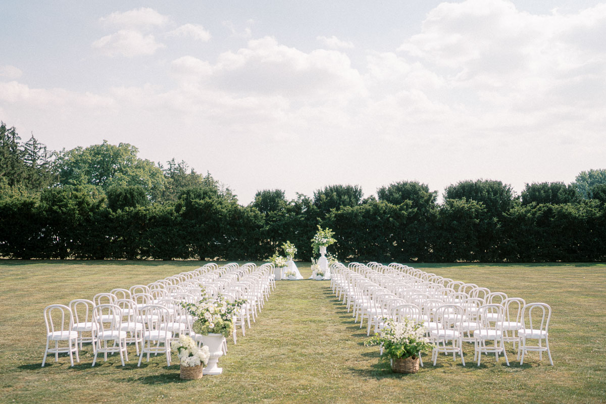An outdoor wedding ceremony setup on the lawn at Martin Estates in Niagara, surrounded by greenery.