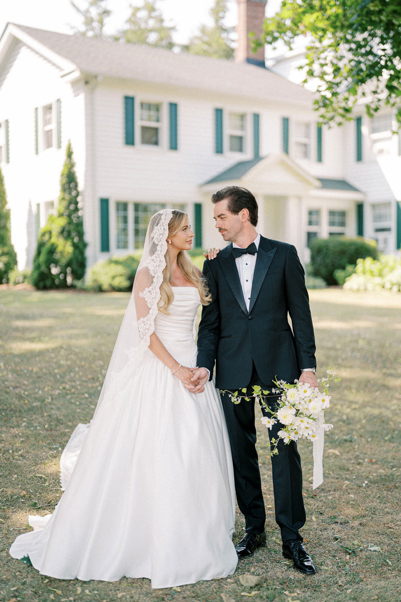 The newlyweds pose in front of the Martin Estates farmhouse during their Niagara wedding day.