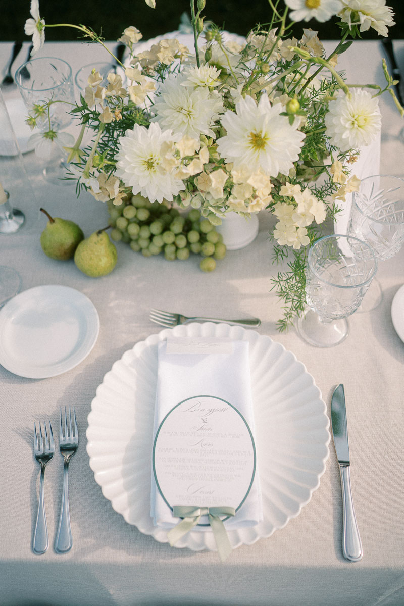 A refined outdoor wedding place setting with white florals and green details at Martin Estates in Niagara.
